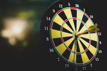Bullseye target goal or dartboard has dart arrow throw hitting center shooting for financial...