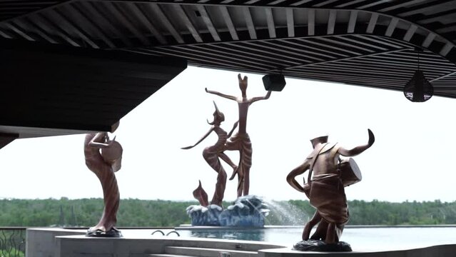 View of the swimming pool and surrounding statues. Replica of a traditional dancer statue