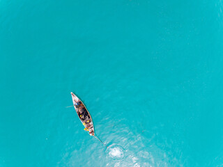 Top view Longtail fisherman boat in the tropical sea at Phuket island Thailand, Beautiful sea surface High angle view from drone camera