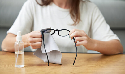Woman, hands and clean glasses from dirt or seeing health, microfiber cloth for lenses. Female...