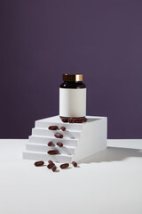 An unbranded medicine bottle is placed on a white podium. Brown capsules are scattered on the steps. Blank label with delicate background for medicine advertising.