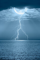 Lightning strikes between clouds with full moon at night 
