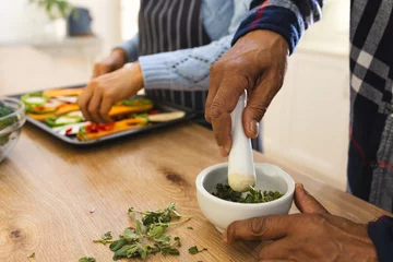  Hands of diverse senior couple preparing healthy meal with vegetables in kitchen © wavebreak3