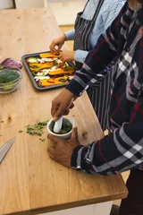  Midsection of diverse senior couple preparing healthy meal with vegetables in kitchen © WavebreakMediaMicro