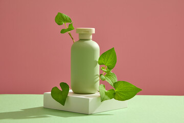 A white podium with empty label bottle and some fish mint leaves placed on. Cosmetic package mock...