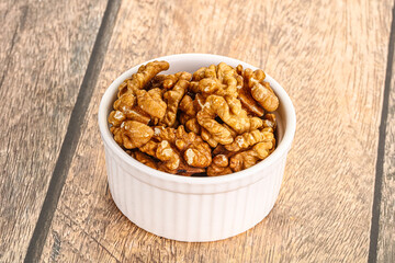 Cracked unshelled walnut in the bowl