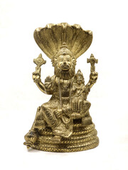 golden statue of lord vishnu avatar, narasimha lion faced with multiple hands sitting on a snake with multiple heads next to goddess lakshmi, front view isolated in a white background