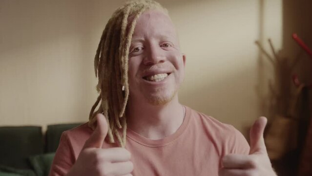 Homem albino sentado na cama dando sinal de positivo. Cinematico 4k.