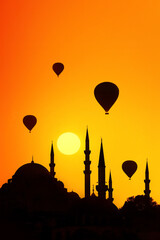 Mosque minarets and hot air balloons at sunset. Istanbul. Türkiye.