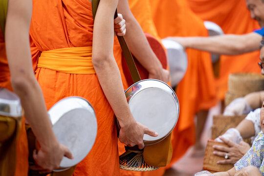 Buddhist alms giving ceremony in the early morning.Monks walk to collect alms and offerings.Sticky rice morning alms giving is held every day in Luang Prabang.Traditional ritual of alms giving in Laos