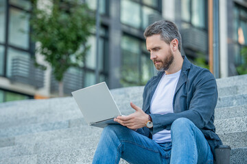 freelance man in the street. freelance man with pc outside.