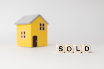 Fototapeta na wymiar Close-up of House model with sold sign, isolated on white background