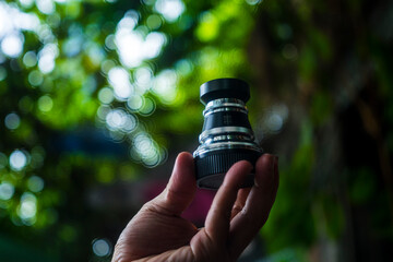 Close-up of camera,Close-up of hand holding camera lens,Old vintage camera placed on a blurred...