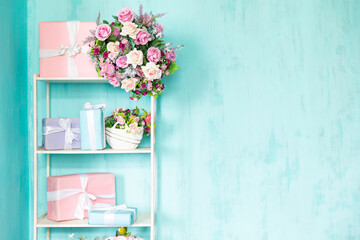 Holiday gifts on a white shelf with flowers