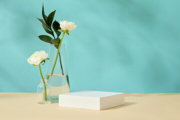 Mockup scene with white empty podium for display products on blue background with glass vase of...