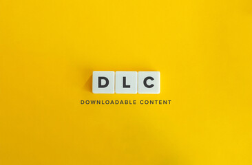 DLC, Downloadable Content. Block Letter Tiles on Yellow Background. Minimal Aesthetic.