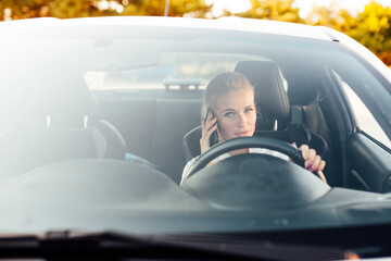 Blonde woman driving a car driver on the road