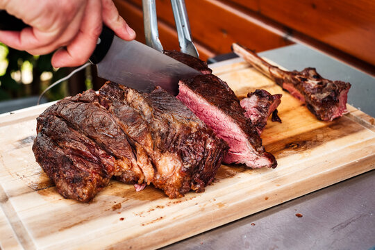 Tomahawk Steak auf Holzbrett geschnitten  - Tomahawk Steak is getting cut on a wooden board