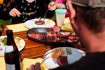 Geschnittenes Tomahawk Steak auf einer Servierplatte platziert auf einem Holztisch bereit um...