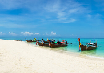 Fototapeta na wymiar Thai traditional wooden longtail boat and beautiful sand beach in Thailand. Traveling concept.