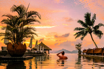 young men in a swimming pool during sunset, a Luxury swimming pool in a tropical resort, relaxing...