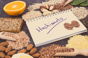 Notepad with inscription hashimoto and best ingredients or products for healthy thyroid. Food as...