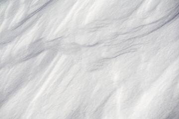 Closeup of snow structure from above. White surface for winter background. Pattern.