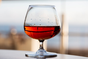 glass of cognac on a wooden table in the bar.