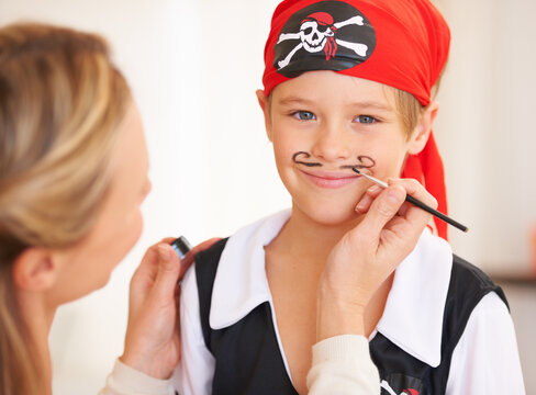 Boy, portrait or pirate face paint with woman, halloween or holiday happiness in childhood in home. Child, mother and theme make up for vacation, clothes and love care for party celebration in house