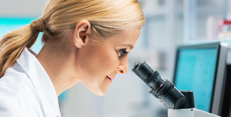 Professional female scientist is working on a vaccine in a modern scientific research laboratory. Laboratory tools: microscope, test tubes, equipment. Future technology, healthcare and science.