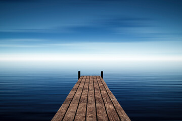 A small wooden pier extending into the blue sea.