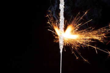 sparkler with sparks on a black background. close-up