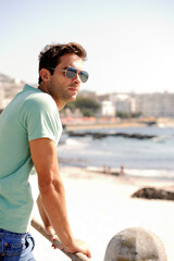 Thinking, fashion and man by ocean in city for summer holiday, vacation and weekend outdoors....