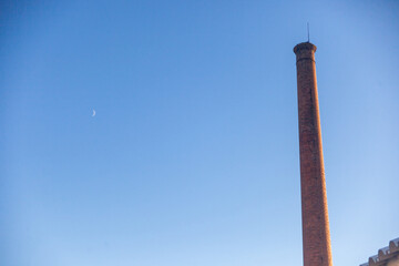Rustic charm captured in an abandoned factory; an aged chimney stands tall, a relic of industrial...