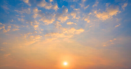 Sunset sky with many golden fluffy clouds and yellow sunlight on horizon sky background in evening...