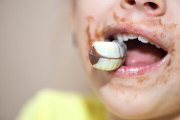 Close up of a child mouth with a chocolate praline