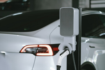 EV electric car recharge at shopping center parking lot charging in downtown city showing urban...