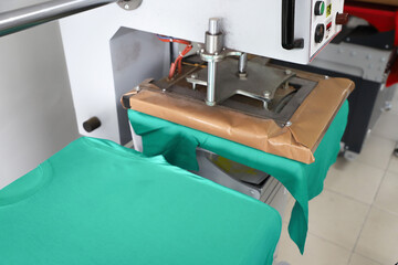 Press printing on colored t-shirts, press for printing images on fabric. Large industrial textile...