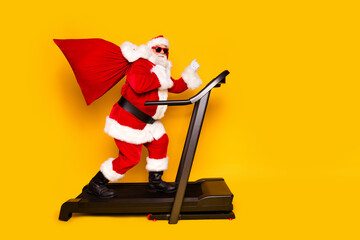 Profile side photo of north pole fantasy character funky santa claus carry presents empty space isolated on yellow color background