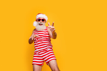 Photo of carefree funky elderly guy wear new year swimsuit hat sunglass enjoying disco empty space isolated yellow color background