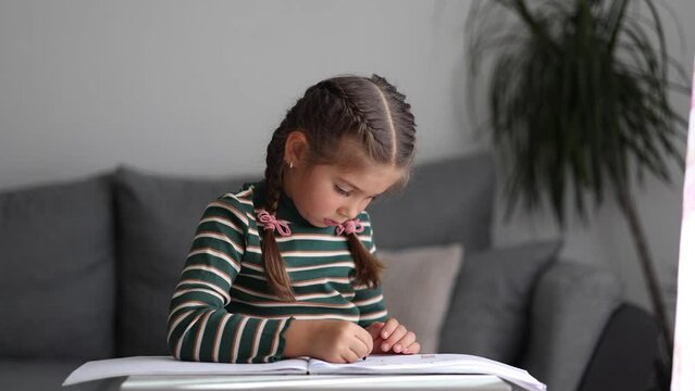 Close-up of adorable girl drawing. Creativity little girl painting at home.
