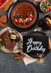 Tasty cake, cookies, waffles, macaroons, muffin. Delicious desserts on dark background. Food concept