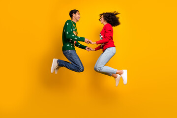 Full length profile portrait of two overjoyed crazy people hold hands jumping new year fairy...