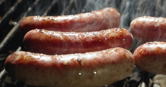 Gather around barbecue as flames dance and hot coals smolder. With every hiss and pop, anticipation of feast of sizzling sausages, tender, juicy and amazing in taste, grows. Copy space, close-up AD