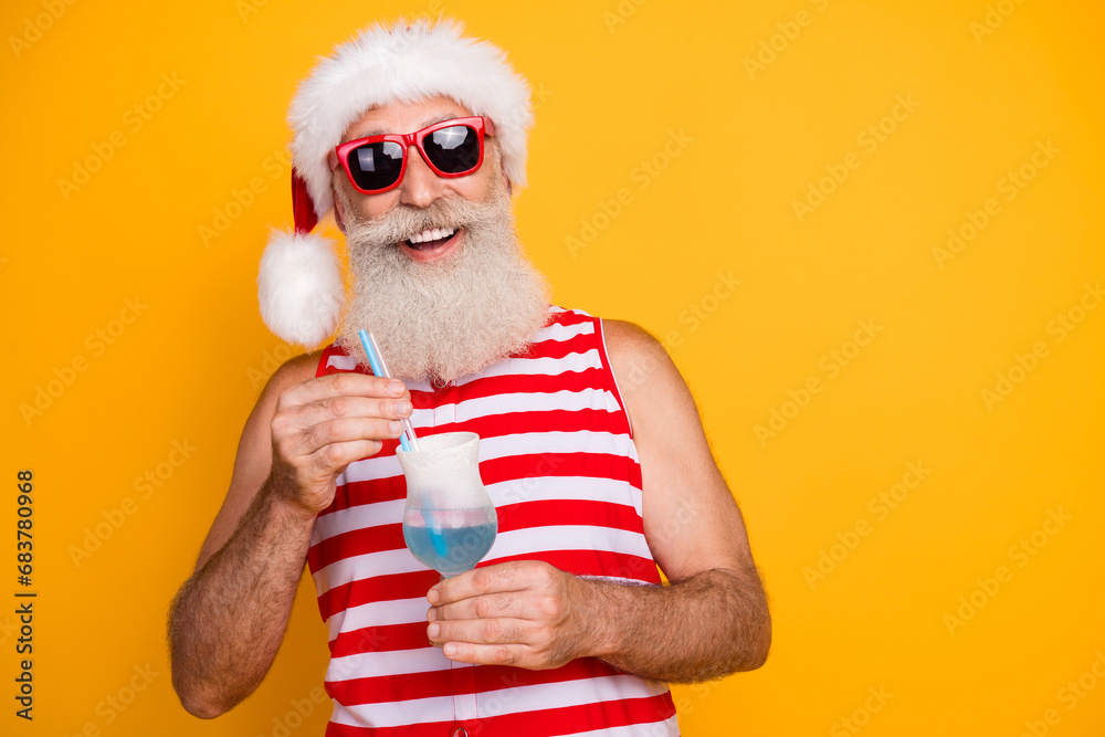 Sticker Photo of excited funky elderly guy wear new year swimsuit hat sunglass enjoying alcohol cocktail empty space isolated yellow color background