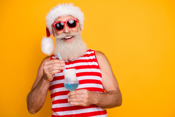 Photo of excited funky elderly guy wear new year swimsuit hat sunglass enjoying alcohol cocktail...