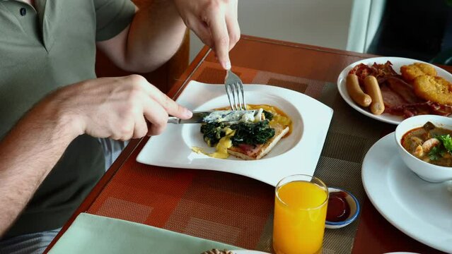 Man enjoys nutritious breakfast with spinach and eggs, promoting healthy eating habits.