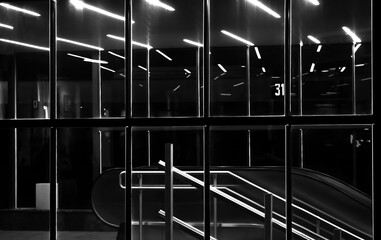 Illuminated glass entrance of the city underground walkway with reflections in the night - 683783584
