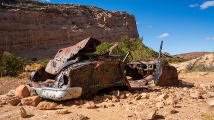 Abandoned mid-century car with many bullet holes in the desert that has been used for target practice for decades