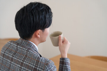 カフェでコーヒーを飲む若い男性
